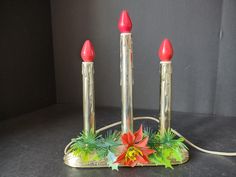 three red candles are sitting on a metal stand