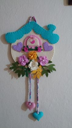 a clock with flowers and hearts hanging from it's side