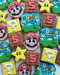 some decorated cookies with mario and other characters on top of each cookie, all in different colors