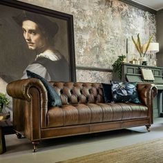 a living room filled with furniture and a painting on the wall