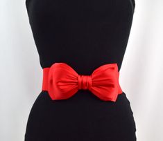 a black dress with a red bow on it