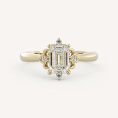 a yellow gold engagement ring with an emerald cut diamond in the center and two diamonds on each side