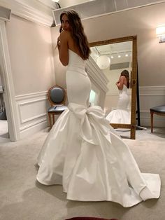 a woman in a white wedding dress is taking a selfie with her cell phone