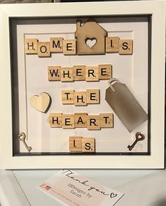 scrabbled wooden letters and keys are arranged in a shadow box with a keychain