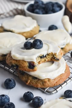 blueberry cookies with icing and fresh blueberries on a cooling rack, ready to be eaten