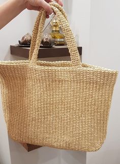 a person holding a straw bag over a counter