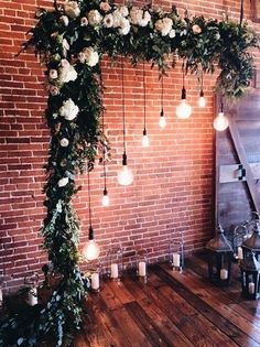 the wedding arch is decorated with white flowers and greenery for an elegant touch to the space