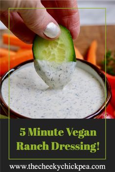 a hand dipping a cucumber into ranch dressing