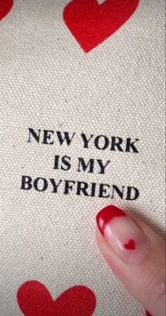 someone is holding onto the back of a pillow with hearts on it that says, new york is my boyfriend