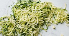 zucchini noodles with white sauce on a marble surface