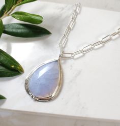 Beautiful rose cut blue lace Agate gemstone set in sterling silver with a sterling silver bead trio design. The Kyanite pendant hangs from a 4mm chunky sterling silver paperclip chain and clasp. D E T A I L S . . . . . . . .  Metal: Sterling Silver Gemstone: Blue Lace Agate Chain Length: 16", 17", 18" Pendant Dimensions: 45mm x 17mm Handmade jewelry with Love and Passion by Grace Lilly Designs. Handcrafted in the USA. Elegant Teardrop Agate Necklace, Elegant Teardrop Pendant Agate Jewelry, Elegant Silver Drop Necklace With Natural Stones, Silver Drop Jewelry With Gemstone Beads, Silver Agate Jewelry With Faceted Detail, Silver Faceted Chalcedony Jewelry, Faceted Silver Chalcedony Jewelry, Silver Chalcedony Jewelry, Faceted, Agate Pendant Necklace