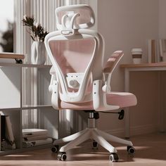 a pink office chair sitting on top of a wooden floor next to a desk and window