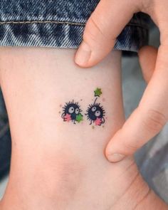 two small tattoos on the side of a woman's stomach