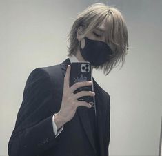 a person wearing a face mask and holding a cell phone in front of their face