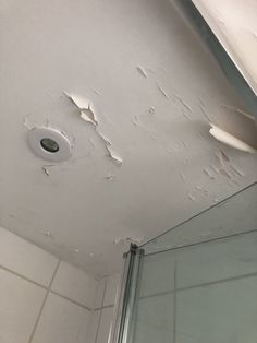 a bathroom ceiling that has been torn off with white paint and water spots on it