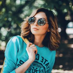 a woman wearing sunglasses and holding a banana