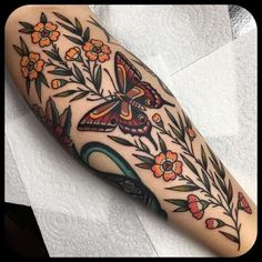 a colorful butterfly and flowers tattoo on the arm