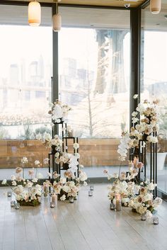 the tables are set up with candles and flowers in vases on each side of them