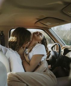 two people kissing in the back seat of a car