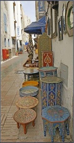 several tables and stools are lined up on the sidewalk