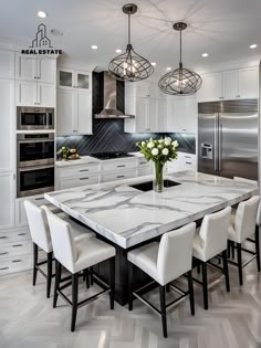 a kitchen with marble counter tops and white chairs in front of an island that has flowers on it