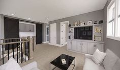 a living room filled with furniture and a flat screen tv on top of a wall