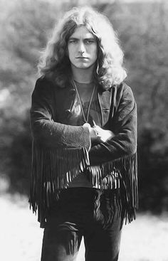 an old black and white photo of a woman with long hair wearing a fringe jacket