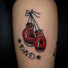 a tattoo with two boxing gloves hanging from it