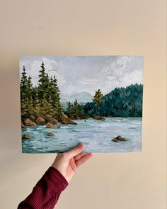 a person holding up a painting in their hand