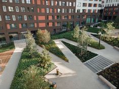 an aerial view of a courtyard with many trees and bushes in the foreground, surrounded by apartment buildings