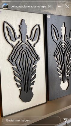 two zebras cut out of wood are displayed on a shelf next to each other