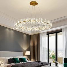 a large bed sitting under a chandelier in a bedroom next to a window