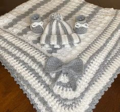 a crocheted blanket and hat on top of a wooden floor