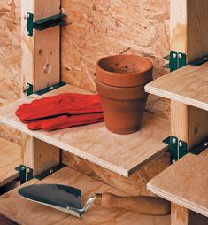 a potted plant sitting on top of wooden shelves next to a knife and red cloth