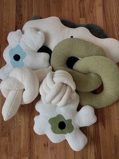 several stuffed animals are laying on the floor next to each other and one has a knot in it's mouth