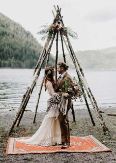 a man and woman standing in front of a teepee