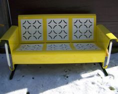 a yellow bench with black and white designs on it's back legs, sitting in the snow