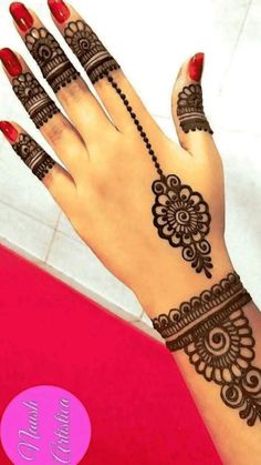 a woman's hand with henna tattoos on it