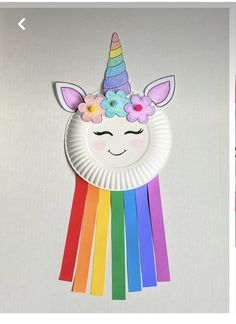 a paper plate with a unicorn face and flowers on it next to an image of a rainbow