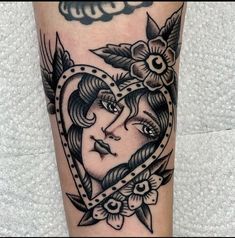 a woman's face in a heart shaped frame with flowers and leaves on her leg