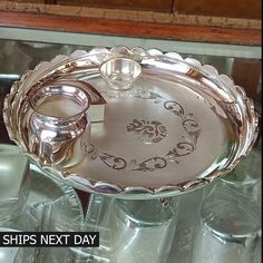 a glass tray with two silver cups on it