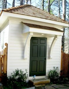 a small white house with a green door