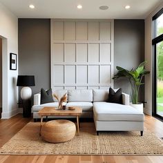 a living room filled with furniture next to a large glass window and wooden flooring