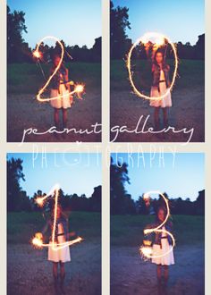 the girl is holding sparklers in her hands and making a heart shape with it