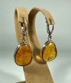 Elevate your style with our Handmade Earrings featuring spectacular orange amber set in textured 925 sterling silver. These exquisite earrings are designed for women who appreciate unique and original jewelry. The vibrant orange amber stones are beautifully complemented by the textured silver, creating a stunning and eye-catching piece that adds a touch of elegance and sophistication to any outfit. Product Details: Material: 925 Sterling Silver Stone: Orange Design: Textured Silver with Unique S Classic Amber Sterling Silver Earrings, Formal Amber Citrine Earrings, Orange Teardrop Sterling Silver Earrings, Amber Citrine Teardrop Earrings, Amber Sterling Silver Dangle Earrings, Amber Sterling Silver Earrings, Amber Sterling Silver Drop Earrings, Formal Baltic Amber Drop Earrings, Formal Baltic Amber Earrings