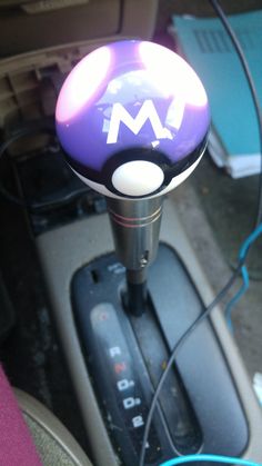 a close up of a steering wheel knob on a car with the letter m painted on it