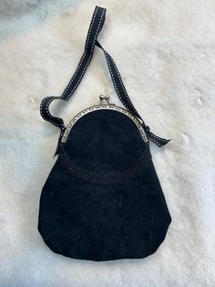 Inspired by museum examples from the late Victorian and Belle Epoque eras this sueded black leather pigskin purse is hand stitched and hand finished. It features a brass-look clasp closure, grosgrain ribbon strap and interior trim, and antique black gimp trim.  Perfect for mourning type-costumes, it is lightweight but very sturdy and large enough to hold a cell phone, keys and a small wallet/coin purse/card holder. The bag measures 4.5" wide at the top and 6.5" at the bottom and is 8" tall. Black Suede Bag For Formal Occasions, Formal Black Leather Coin Purse, Black Victorian Style Bags For Formal Occasions, Vintage Shoulder Bag With Leather Trim And Double Handle, Handmade Black Leather Coin Purse, Black Leather Handmade Coin Purse, Vintage Black Evening Bag With Detachable Strap, Vintage Black Satchel With Zipper Closure, Vintage Black Shoulder Bag With Brass Hardware