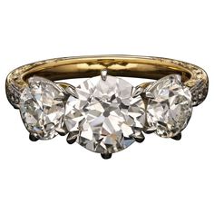 three stone diamond ring with two diamonds in the middle and an old - fashioned band