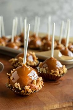 caramel and nuts on top of chocolate covered desserts with white sticks sticking out of them