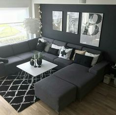 a living room with black and white decor on the walls, couches and coffee table